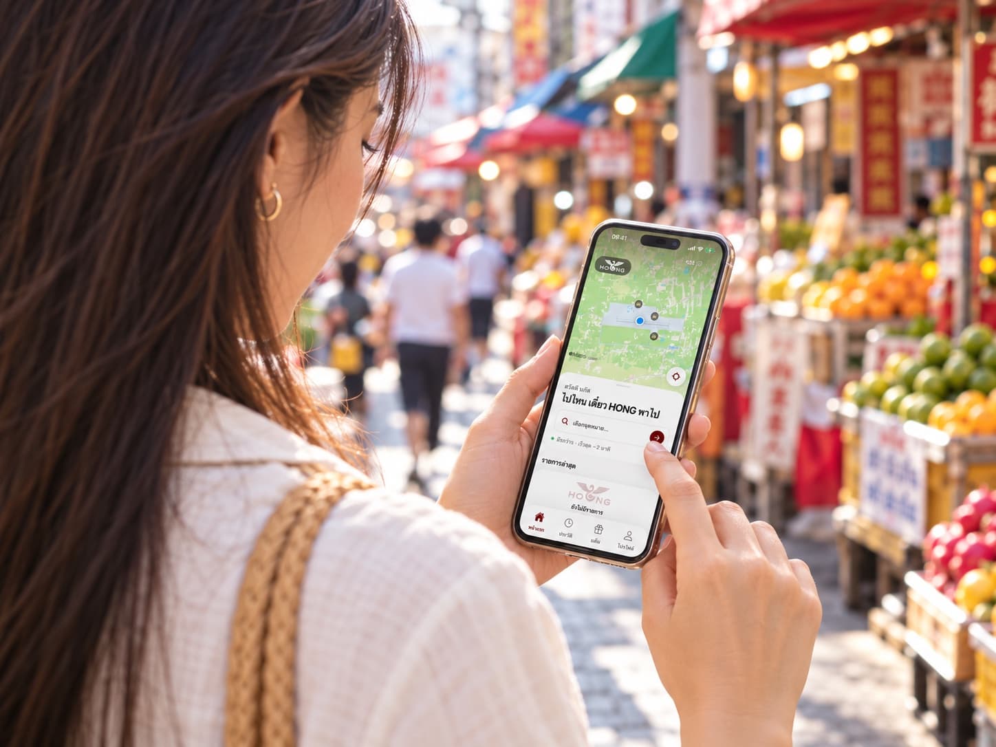 ภาพสร้างใหม่มุมข้ามไหล่ ผู้หญิงมองและแตะหน้าจอ Hong App ในตลาดหาดใหญ่